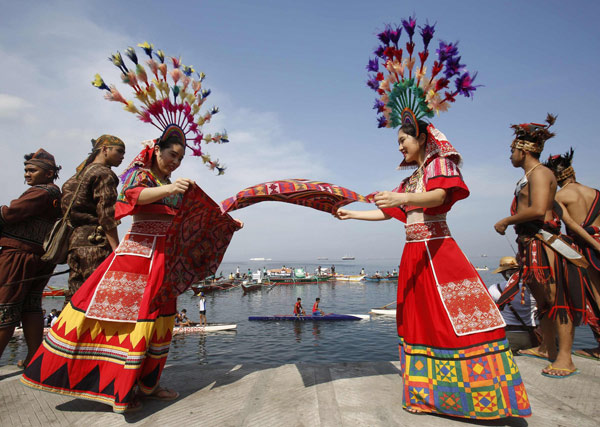 Des écologistes et artistes du Centre Culturel des Philippines, habillés de costumes traditionnels, se sont rassemblés sur un muret proche de la mer, pour se joindre à l'événement "Sauver la baie de Manille" pendant les célébrations de la Journée la Terre à Manille 21 Avril 2013. [Photo/agences ]