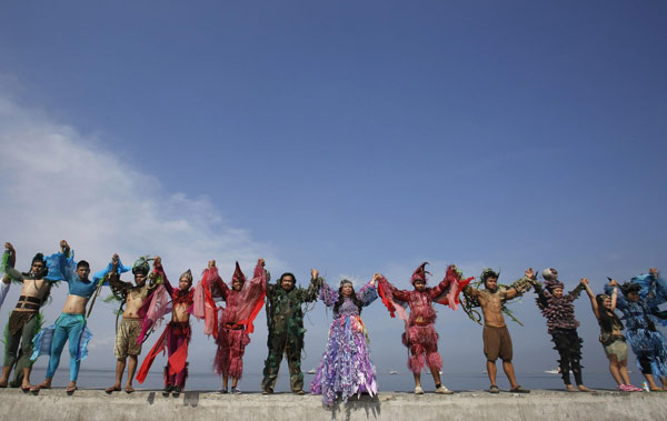 Des écologistes et artistes du Centre Culturel des Philippines, portant un habit traditionnel, se prennnent pour soutenir l'événement «Sauver la baie de Manille» au cours des célébrations de la Journée la Terre à Manille le 21 avril 2013. [Photo/agences]