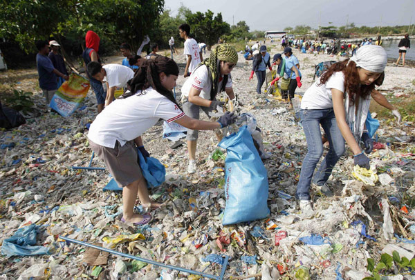 Des étudiants, bénévoles et activistes environnementaux occupés à nettoyer le littoral de la zone d'habitation et d'écotourisme de Paranaque, incluant une forêt de mangroves et un sanctuaire d'oiseaux, dans le cadre de la commémoration de la journée de la Terre à Manille, le 20 avril 2013. [Photo/agences]