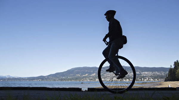 L'unicycliste Dal roule le long de la digue dans le parc de Stanley lors de la Journée de la Terre à Vancouver, Colombie-Britannique, le 22 avril 2013. Dal qui a aujourd'hui 65 ans monte sur son monocycle depuis plus de 10 ans. [Photo/agences]