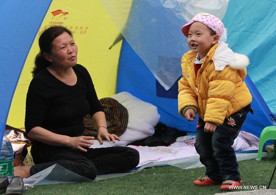 Le petit garçon Zhu Ziwei âgé de 2 ans danse pour sa grand-mère dans un camp d'abris de sinistrés du comté de Baoxing dans la province chinoise du Sichuan, frappé le 20 avril par un séisme de magnitude 7. (Photo : Xinhua/Pei Xin)