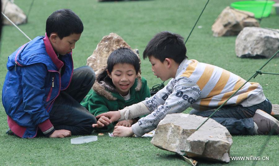 Le 22 avril 2013, des garçons jouent aux échecs dans un camp d'abris temporaire de sinistrés à Baoxing, un comté de la province du Sichuan frappé par un séisme de magnitude 7, samedi 20 avril 2013. (Photo : Xinhua/Pei Xin)