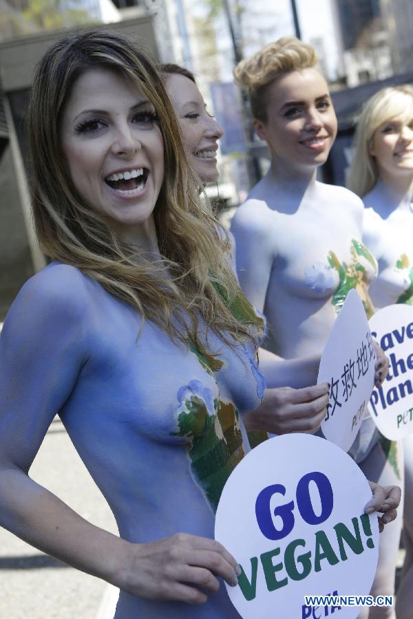 Des membres de l'Association People for the Ethical Treatment of Animals (PETA), tous nus et se peignant en vert et bleu, manifestent dans le centre-ville de Vancouver, au Canada, le 22 avril 2013, dans le cadre de la 43e édition de la Journée mondiale de la terre. (Xinhua/Liang Sen)
