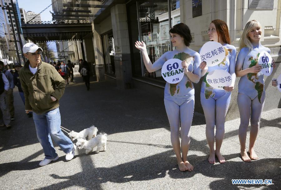 Des membres de l'Association People for the Ethical Treatment of Animals (PETA), tous nus et se peignant en vert et bleu, manifestent dans le centre-ville de Vancouver, au Canada, le 22 avril 2013, dans le cadre de la 43e édition de la Journée mondiale de la terre. (Xinhua/Liang Sen)