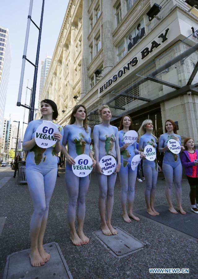 Des membres de l'Association People for the Ethical Treatment of Animals (PETA), tous nus et se peignant en vert et bleu, manifestent dans le centre-ville de Vancouver, au Canada, le 22 avril 2013, dans le cadre de la 43e édition de la Journée mondiale de la terre. (Xinhua/Liang Sen)