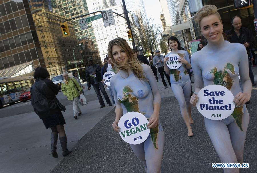 Des membres de l'Association People for the Ethical Treatment of Animals (PETA), tous nus et se peignant en vert et bleu, manifestent dans le centre-ville de Vancouver, au Canada, le 22 avril 2013, dans le cadre de la 43e édition de la Journée mondiale de la terre. (Xinhua/Liang Sen)