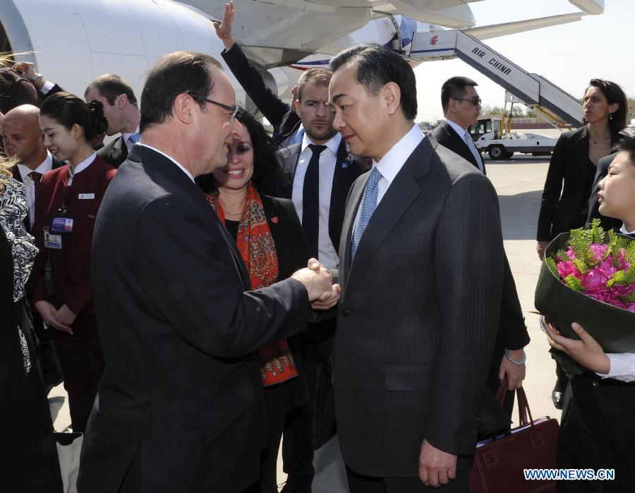 Le président français François Hollande accueilli par le ministre chinois des Affaires étrangères Wang Yi à son arrivée le 25 avril 2013 à Beijing.