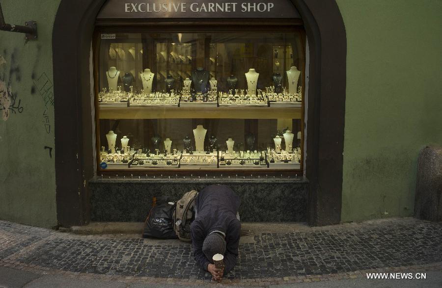 Le 25 avril, un mendigot devant la vitrine d'un magasin de bijoux, à Prague, la capitale tchèque. (Photo: Xinhua/AFP) (Photo: Xinhua/Reuters) 