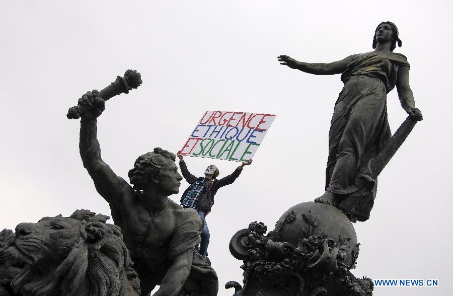 Un manifestant tenant une bannière participe à la manifestation annuelle du 1er mai à Paris. (Xinhua/Etienne Laurent)