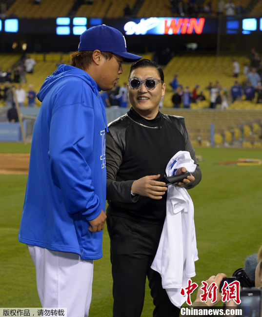 Le lanceur de Los Angeles Dodgers Hyun-Jin Ryu parle avec le rappeur sud-coréen PSY après le match, à Los Angeles le 30 avril 2013.