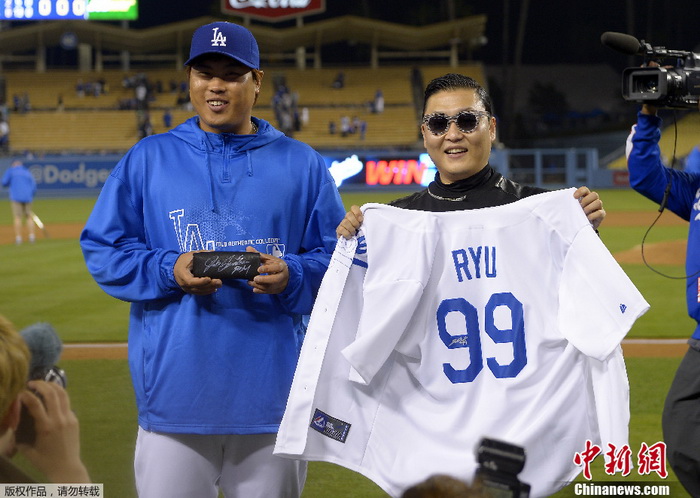 Le lanceur de Los Angeles Dodgers Hyun-Jin Ryu présente son maillot au rappeur sud-coréen PSY après le match, à Los Angeles le 30 avril 2013.