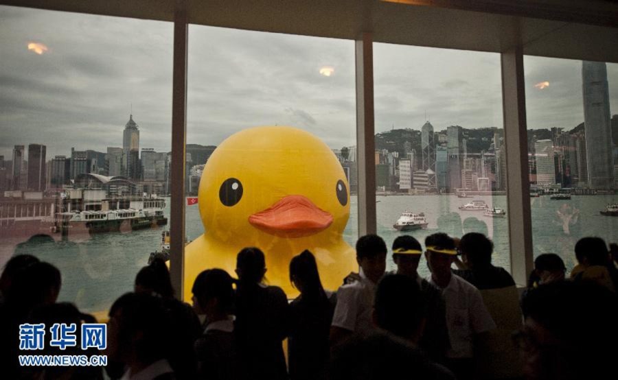 Le 2 mai au port Victoria de Hong Kong, des touristes devant le plus grand canard en plastique du monde venant d'arriver à Hong Kong. (Photo : Xinhua/Lv Xiaowei)