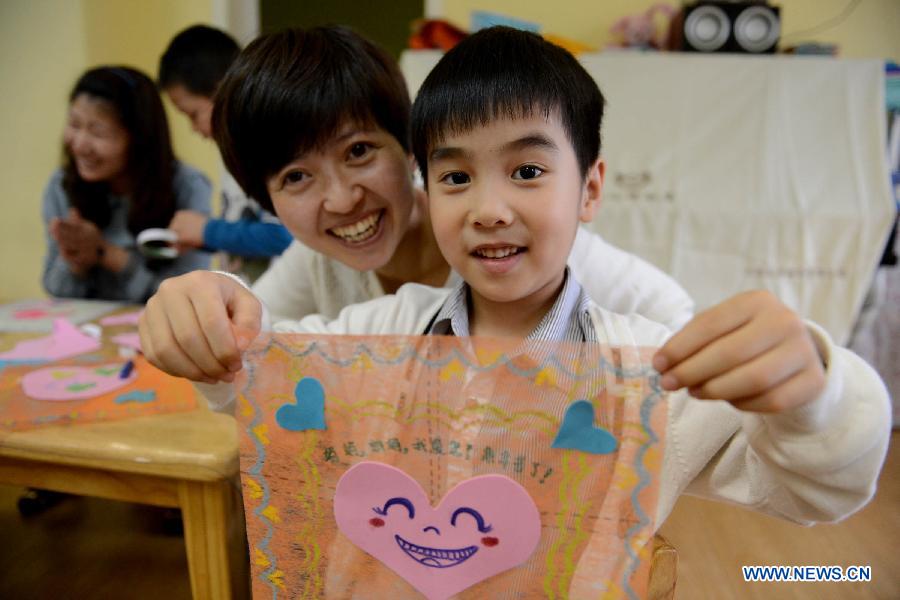 Le 9 mai 2013 dans une école maternelle à Hefei, capitale de la province chinoise de l'Anhui, un garçon est fier de montrer le mouchoir qu'il a confectionné pour sa mère. (Photo : Xinhua/Zhang Duan)