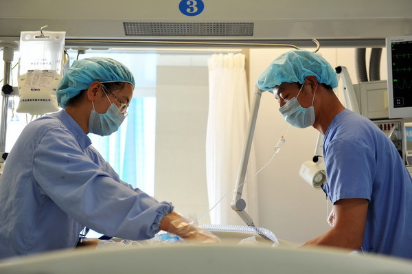 Zeng Lei et un travail de collègue s'occupent d'un patient à l'hôpital affilié à l'université médicale du Ningxia dans la Région Autonome Hui du Ningxia, le 8 avril. [Photo / Xinhua]