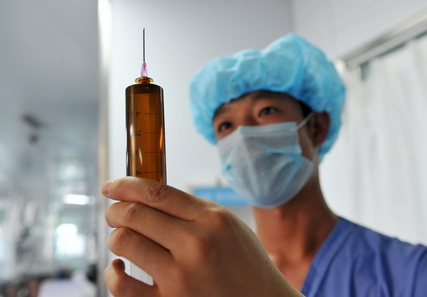Zeng Lei, 24 ans, expulse l'air d'une seringue dans l'unité de soins intensifs de l'hôpital affilié à l'université médicale du Ningxia dans la Région Autonome Hui du Ningxia, le 8 avril. Zeng est devenu infirmier après avoir obtenu son diplôme de l'université en 2011.[Photo / Xinhua]