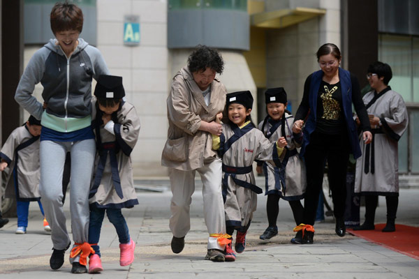 Des enfants pratiquent des jeux de société avec leurs proches, lors d'un cours de formation à Changchun, la province de Jilin au nord de la Chine, le 11 mai 2013. [Photo/Xinhua]