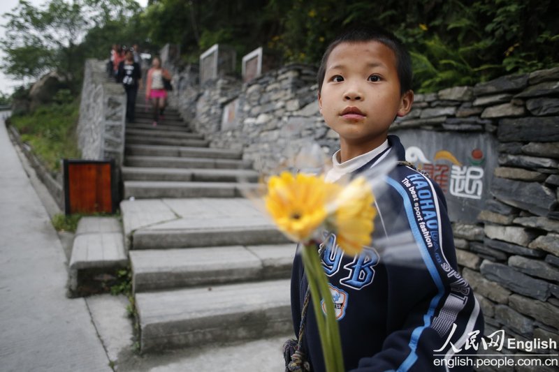 Un petit garçon vend des chrysanthèmes en dehors du Musée commémoratif du séisme de Wenchuan le 29 avril 2013. (Photo : CFP)