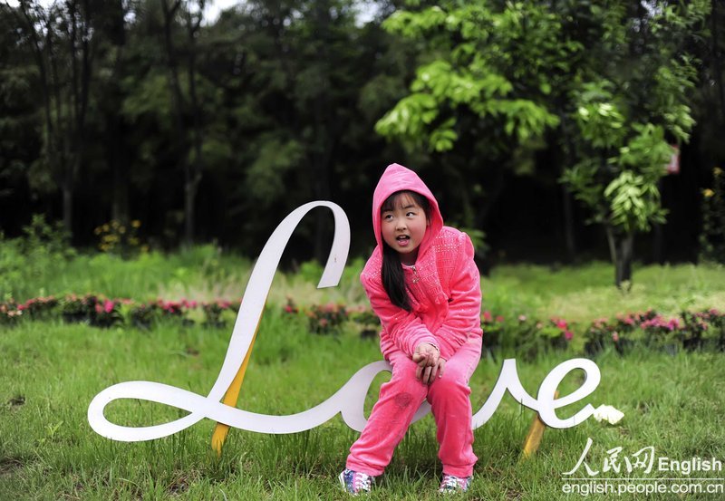 Le 5 mai 2013, Song Xinyi, âgée de 8 ans, pose pour une photo dans un parc à Dujiangyan au Sichuan. Dans le séisme de Wenchuan en 2008, la petite fille a été ensevelie dans les ruines de maisons pendant 40 heures et se trouvait sous les dépouilles de ses parents. (Photo : CFP)