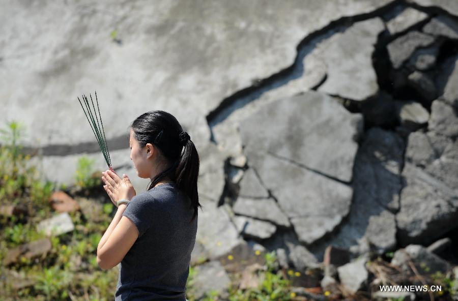 Le 12 mai 2013 à Beichuan dans la province du Sichuan, une femme rend hommage aux victimes du séisme de Wenchuan qui a frappé la région il y a cinq ans. (Photo : Xinhua/Xue Yubin)