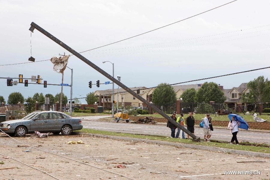 Le 21 mai 2013 à Moore dans l'Oklahoma aux Etats-Unis, après le passage d'une tornade, des habitants marchent dans les décombres. (Xinhua/Song Qiong)