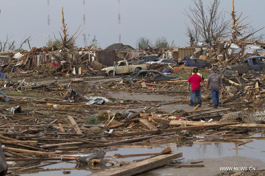 Le 20 mai 2013 à Moore, dans l'Etat américain d'Oklahoma, plusieurs personnes marchent dans les décombres, après le passage d'une tornade mortelle. (Xinhua/Marcus DiPaola)