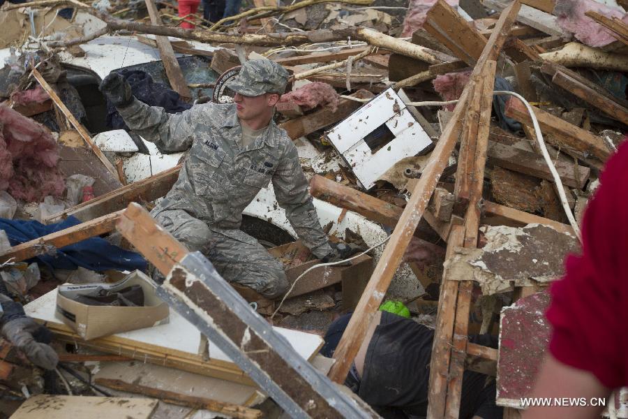 Le 20 mai 2013 à Moore dans l'Oklahoma, un militaire de l'Armée de l'air américaine demande de l'aide lors des recherches des survivants dans les décombres laissés ce lundi par une puissante tornade. (Xinhua/Marcus DiPaola)