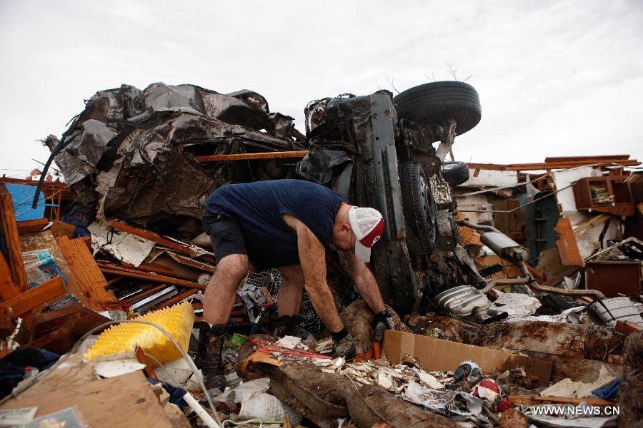 Le 21 mai 2013, le lendemain du passage d'une tornade mortelle à Moore en Oklahoma, un résident de la ville déblaie les décombres et les déchets. (Xinhua/Song Qiong)