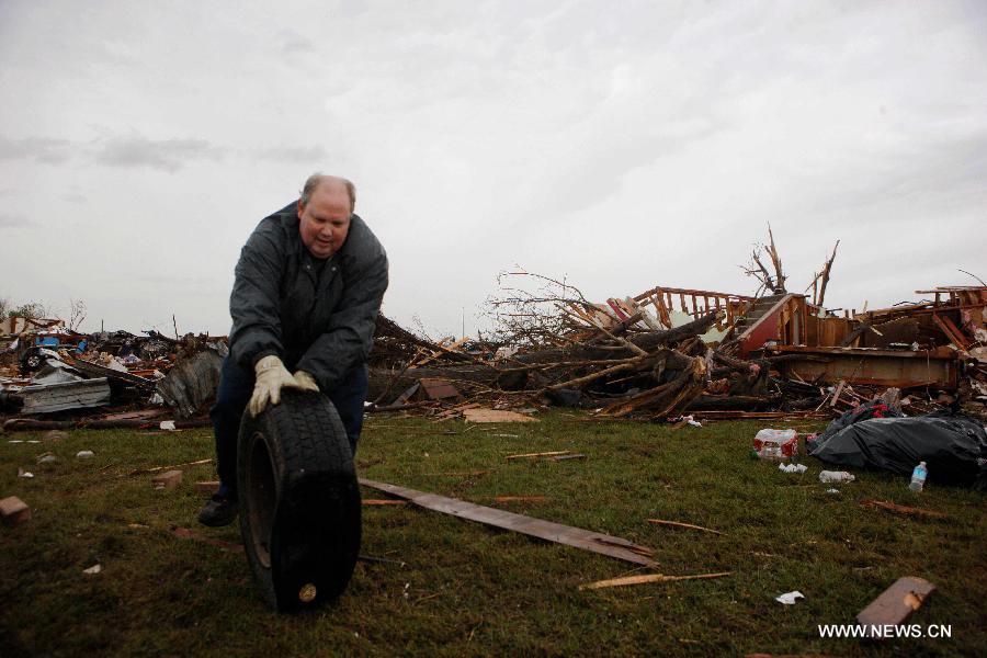 Le 21 mai 2013, le lendemain du passage d'une tornade mortelle à Moore en Oklahoma, un résident de la ville déblaie les décombres et les déchets. (Xinhua/Song Qiong)