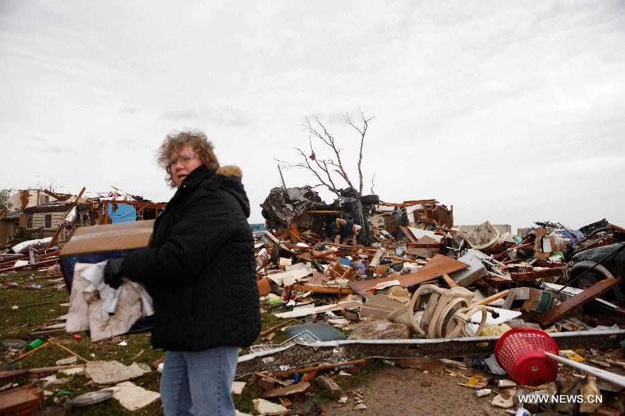 Le 21 mai 2013, le lendemain du passage d'une tornade mortelle à Moore dans l'Oklahoma, une habitante de la ville deblaie les décombres et les détritus. (Xinhua/Song Qiong)