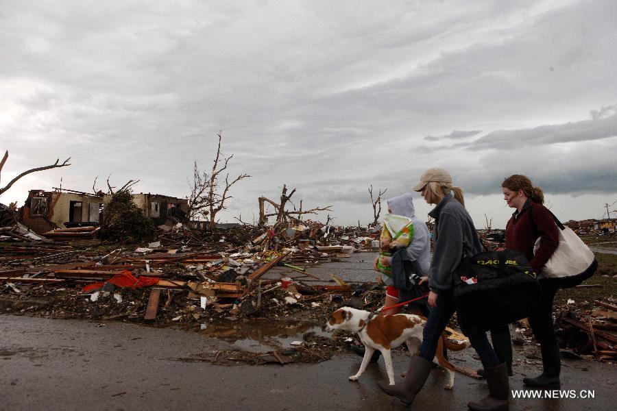 Le 20 mai 2013 à Moore, dans l'Etat américain d'Oklahoma, plusieurs personnes marchent dans les décombres, après le passage d'une tornade mortelle. (Xinhua/Marcus DiPaola)