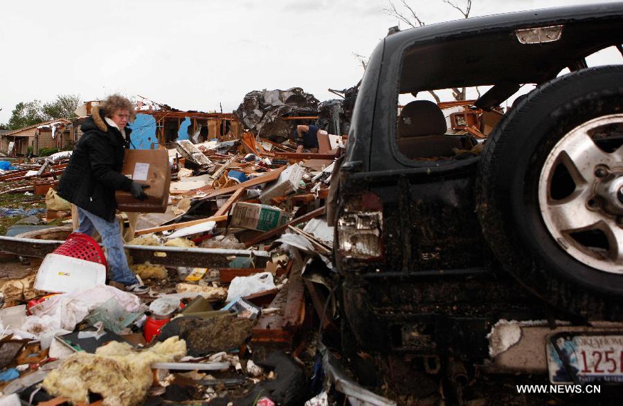 Le 21 mai 2013, le lendemain du passage d'une tornade mortelle à Moore dans l'Oklahoma, une habitante de la ville deblaie les décombres et les détritus. (Xinhua/Song Qiong)