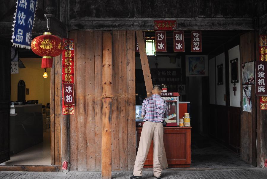 Un habitant ferme sa boutique à Anren, une ville ancienne du Comté de Dayi, à Chengdu, capitale de la Province du Sichuan, dans le Sud-ouest de la Chine, le 23 mai 2013.