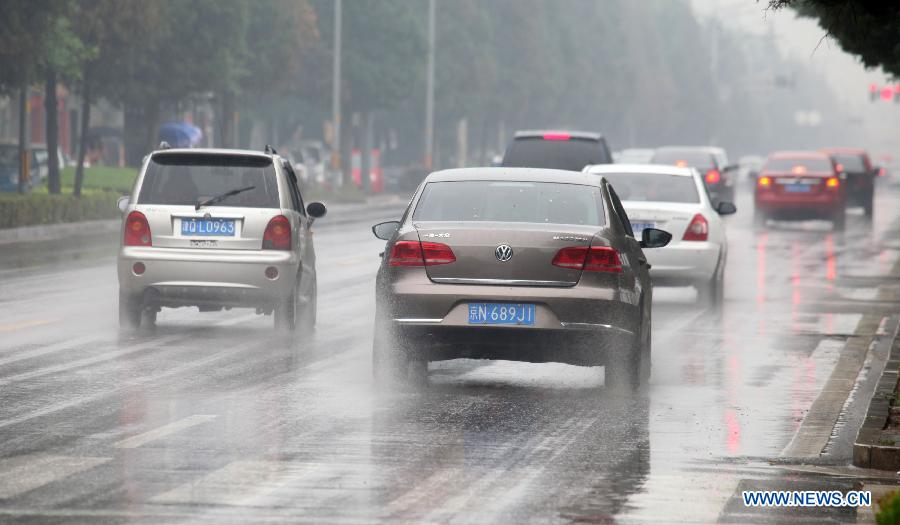 Des voitures roulent sur la route dans l'arrondissement de Huairou à Beijing, capitale de la Chine, le 4 juin 2013. De fortes pluies ont frappé le nord de Beijing mardi.