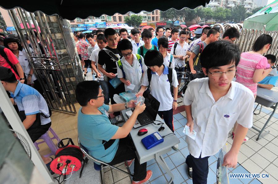 Des candidats arrivent pour participer au concours d'entrée à l'université à une école secondaire à Fuzhou, capitale de la province du Fujian (sud-ouest de la Chine), le 7 juin 2013. Quelque 9,12 millions de candidats devraient participer au concours d'entrée à l'université cette année qui commence vendredi.