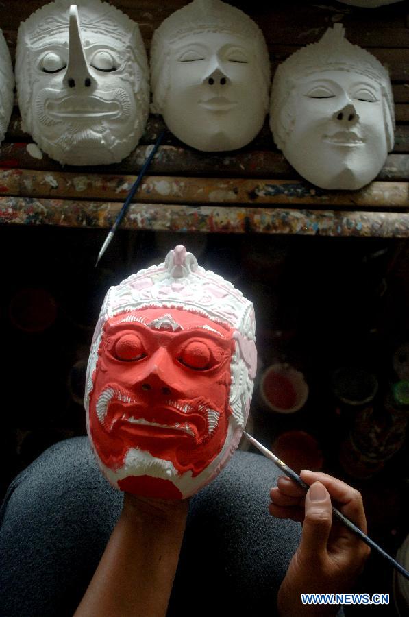 Un homme peint un Topeng Malang, ou le masque de Malang, dans un atelier de masque à Malang, dans l'est de Java, en Indonésie, le 6 juin 2013. (Xinhua/Hidayat)