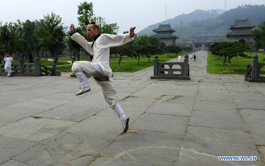 Un apprenant étranger pratique des mouvements d'arts martiaux chinois au Palais Yuxu, sur le Mont Wudang, connu pour être un centre traditionnel de l'enseignement et de la pratique des arts martiaux, dans la Province du Hubei, dans le Centre de la Chine, le 5 juin 2013. [Photo / Xinhua]