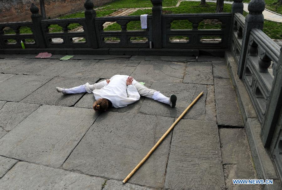 Un apprenant étranger s'échauffe avant de pratiquer les arts martiaux chinois au Palais Yuxu, sur le Mont Wudang, connu pour être un centre traditionnel de l'enseignement et de la pratique des arts martiaux, dans la Province du Hubei, dans le Centre de la Chine, le 5 juin 2013. [Photo / Xinhua]