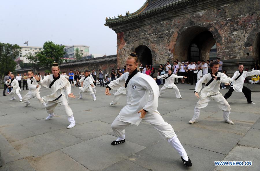 Des apprenants étrangers pratiquent des mouvements d'arts martiaux chinois au Palais Yuxu, sur le Mont Wudang, connu pour être un centre traditionnel de l'enseignement et de la pratique des arts martiaux, dans la Province du Hubei, dans le Centre de la Chine, le 5 juin 2013. [Photo / Xinhua]