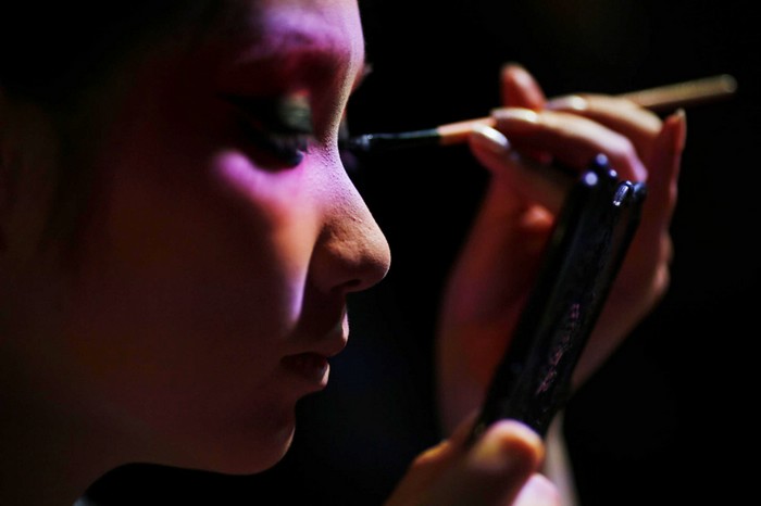 Une artiste prise en photo alors qu'elle applique son maquillage avant une avant-première d'un spectacle d'Opéra de Pékin réservée aux médias, au musée des textiles de Shanghai, le 8 juin 2013.