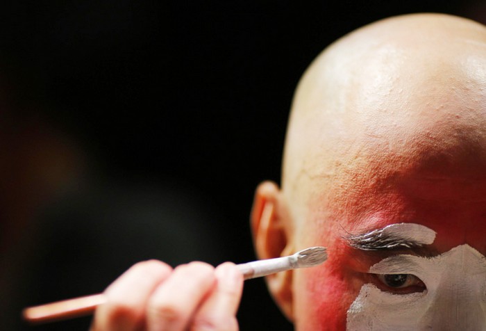 Un artiste applique son maquillage avant une avant-première d'un spectacle d'Opéra de Pékin réservée aux médias, au musée des textiles de Shanghai, le 8 juin 2013.