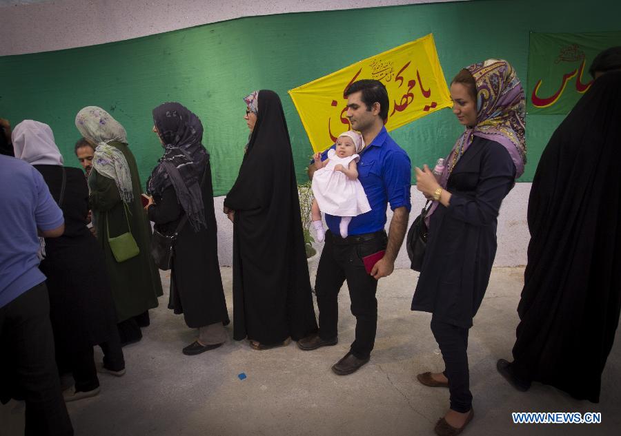 Des électeurs iraniens font la queue pour voter à un bureau de vote dans le nord de Téhéran, en Iran, le 14 juin 2013. Le dirigeant suprême de l'Iran, l'ayatollah Ali Khamenei, a voté à l'élection présidentielle iranienne et déclaré l'ouverture du scrutin vendredi matin. (Photo: Xinhua/Ahmad Halabisaz)