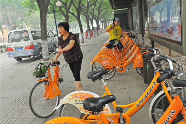 Des habitants louent des vélos publics pour rouler dans la ville de Qingzhou, dans la Province du Shandong, le 17 juin 2013. La Journée Nationale du Bas Carbone a eu lieu cette année le 17 juin 2013, sur le thème « Ayez une attitude pauvre en carbone et construisez de belles maisons ». [Photo Wang Jilin / Asianewsphoto]