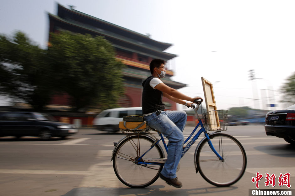 Fucha Danqing passe devant la tour du tambour à bicyclette. C'est l'endroit où il peint souvent. A bicyclette, il choisit souvent les endroits de ce coin pour réaliser ses œuvres d'art.