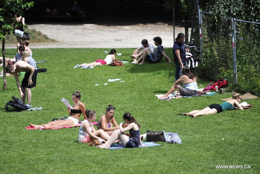 Les étudiants étudient dans un parc près de l'Université catholique de Louvain, à Louvain, en Belgique, le 18 juin 2013.La température a atteint 31°C, la plus haute depuis cette année, suivi d'un hiver et printemps aussi froid et humide. (Xinhua/Ye Pingfan)