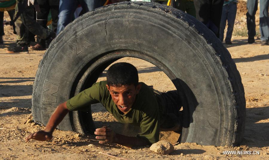 Un garçon palestinien participe à un exercice militaire lors d'une cérémonie de fin d'études d'une école militaire organisée par le hamas dans la ville de Rafah, dans le sud de Gaza, le 19 juin 2013. (Xinhua/Khaled Omar)