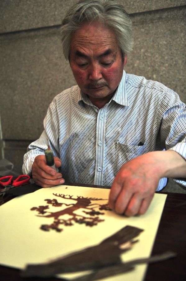 Le 19 juin 2013, Su Yongsheng en pleine création d'une peinture d'écorce lors d'une exposition d'art folklorique au Musée d'art dans le Gansu à Lanzhou, capitale de la province chinoise. (Photo : Xinhua/Liang Qiang)