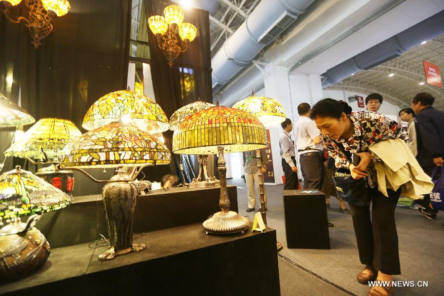 Une visiteuse regarde des lampes lors de l'exposition Luxury China 2013 à Beijing, le 22 juin 2013. Cette exposition de 3 jours a débuté samedi, avec la participation de plus de 300 exposants. [Photo / Xinhua]