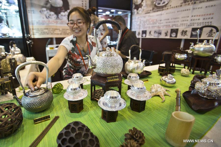 Une exposante présente un service à thé en argent lors de l'exposition Luxury China 2013 à Beijing, le 22 juin 2013. Cette exposition de 3 jours a débuté samedi, avec la participation de plus de 300 exposants. [Photo / Xinhua]