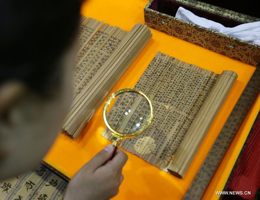 Un visiteur regarde des lamelles de bambou (utilisés pour écrire dans la Chine ancienne) lors de l'exposition Luxury China 2013 à Beijing, le 22 juin 2013. Cette exposition de 3 jours a débuté samedi, avec la participation de plus de 300 exposants. [Photo / Xinhua]