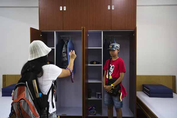 Une visiteuse prend une photo d'un garçon portant une casquette de l’APL lors d'une journée portes ouvertes à la caserne Shek Kong à Hong Kong le 30 juin 2013. [Photo / agences]
